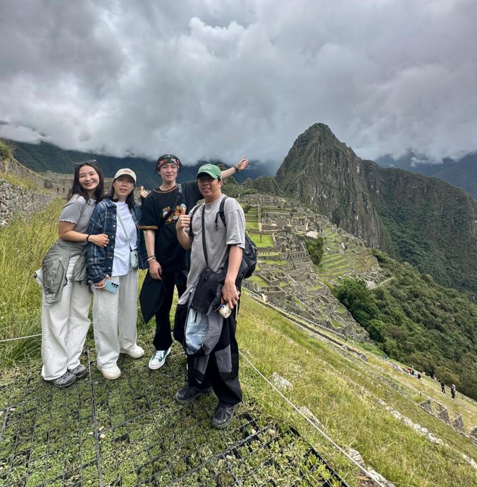 Visitors enjoying a scenic view of Machu Picchu with Huayna Picchu mountain in the background