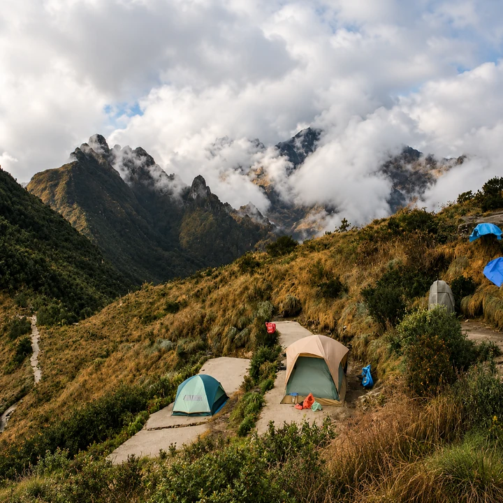 Tents on a mountain campsite beneath low clouds.