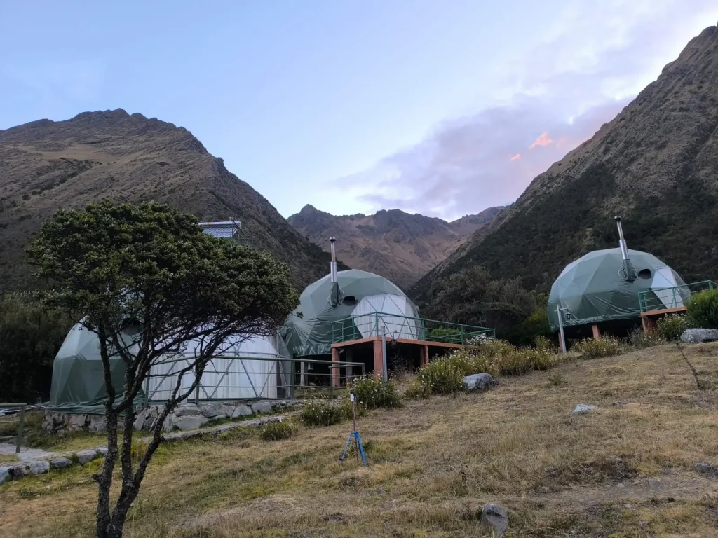 Mountain accommodation domes surrounded by Andean peaks along the Salkantay Trek in Peru.