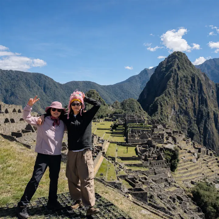 Two women celebrating their visit to Machu Picchu under an Andean sky