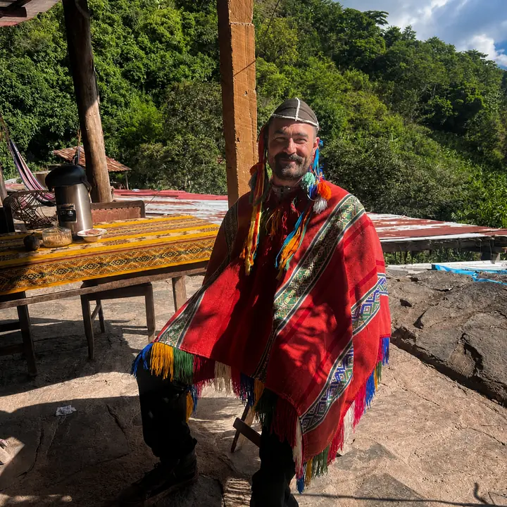 Traveler wearing a red Andean poncho at a jungle rest stop.