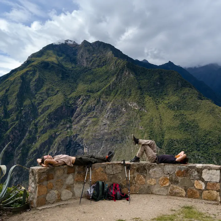 Trekkers resting beside pack mules on the Choquequirao route.