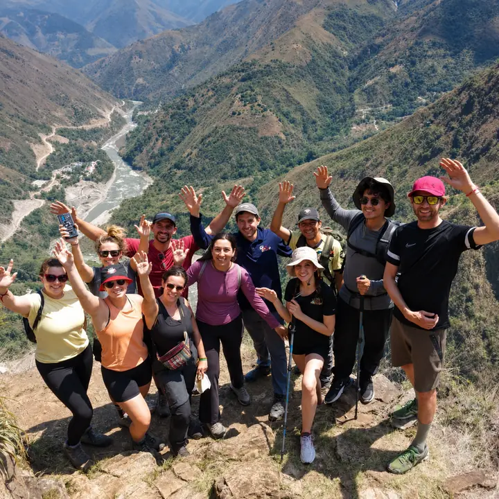 Hiking group posing at a viewpoint above a winding Andean river.
