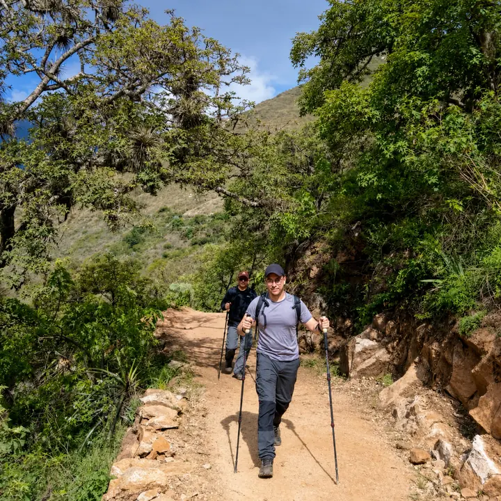Woman hiking with trekking poles on the Choquequirao trail.