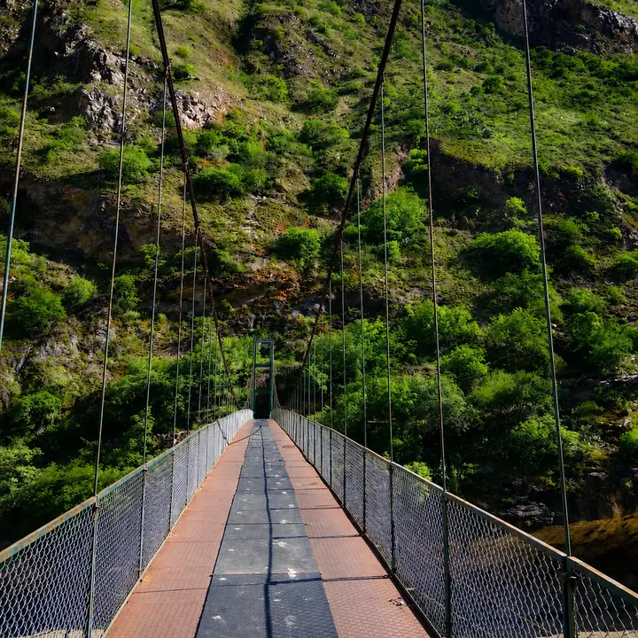 Suspension bridge spanning a green valley on the Choquequirao trek.