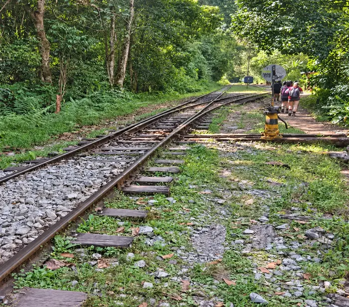 Travelers walking beside the railway from Hidroelectrica to Machu Picchu.