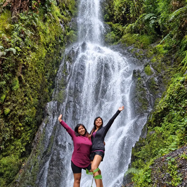 Travelers enjoying a waterfall in the Manu rainforest.