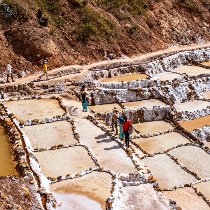Visitors walking between salt ponds at the Maras Salt Mines.