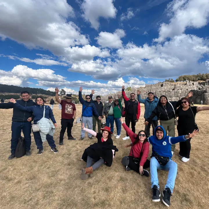 Travel group celebrating at Sacsayhuaman during a Cusco City Tour.