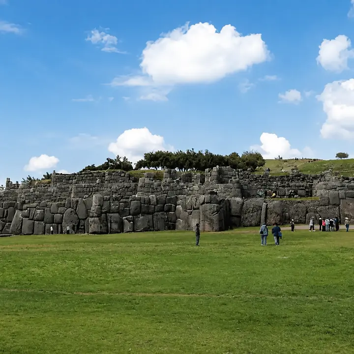 Massive Inca stone walls and open field at Sacsayhuaman in Cusco, Peru.
