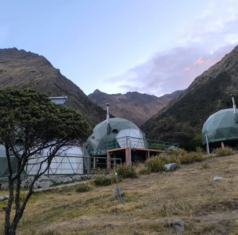 Mountain accommodation domes surrounded by Andean peaks along the Salkantay Trek in Peru.