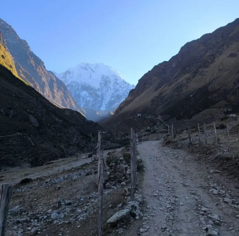 Rocky trail through an Andean valley leading toward the snow-covered Salkantay Mountain in Cusco, Peru.